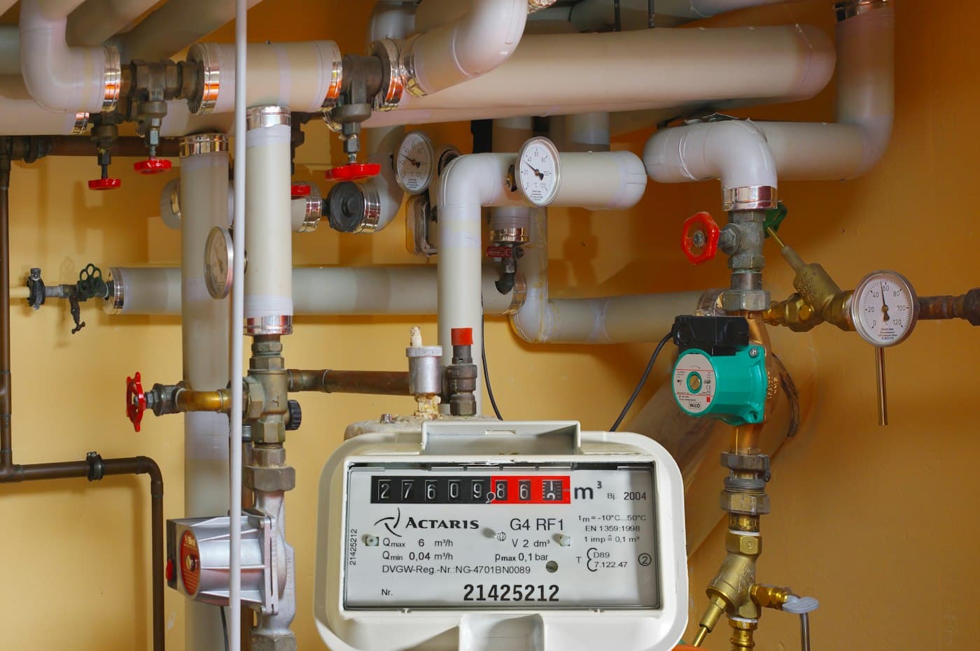A gas meter and heating pipework in a plant room