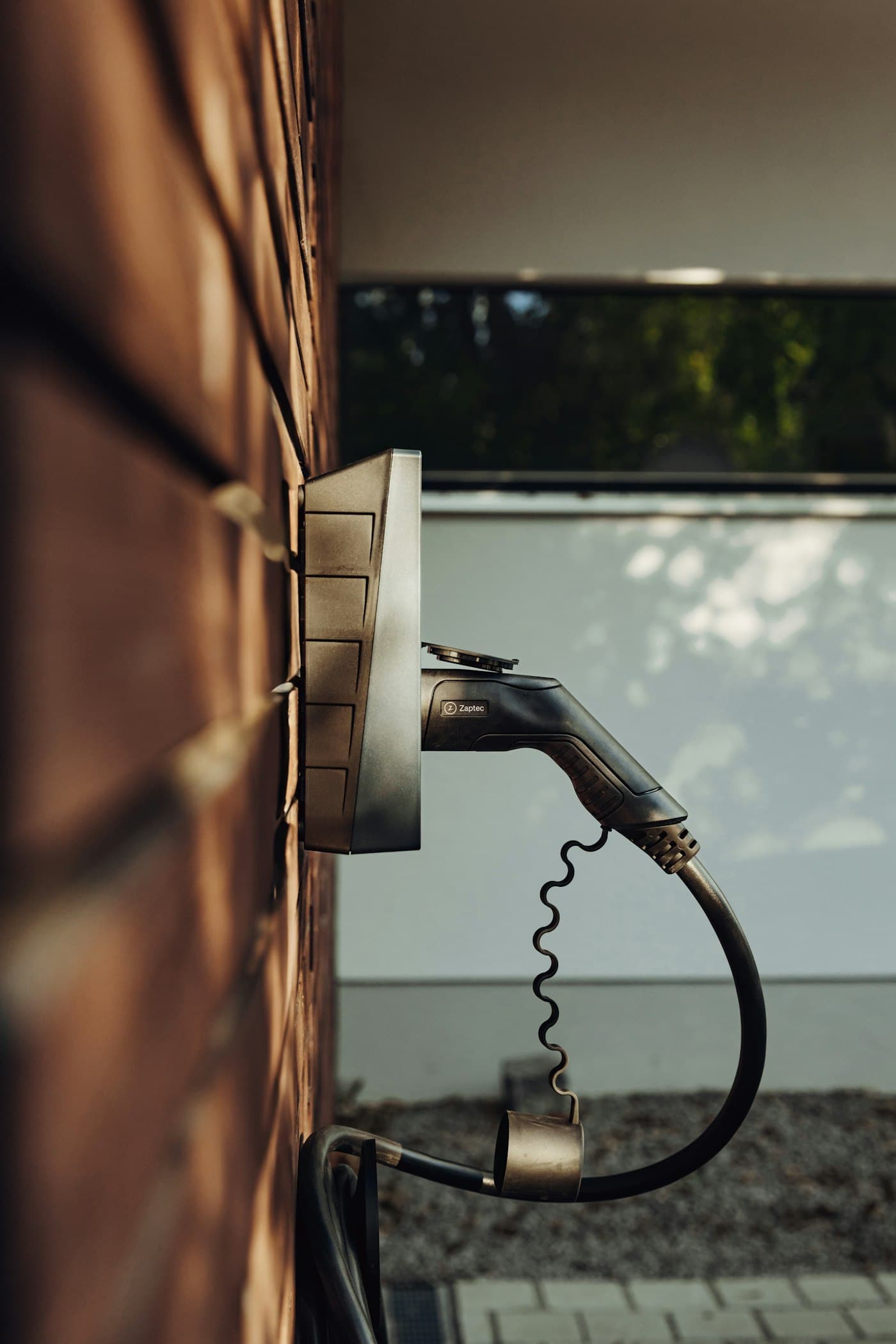 A home EV charger mounted on a brick wall