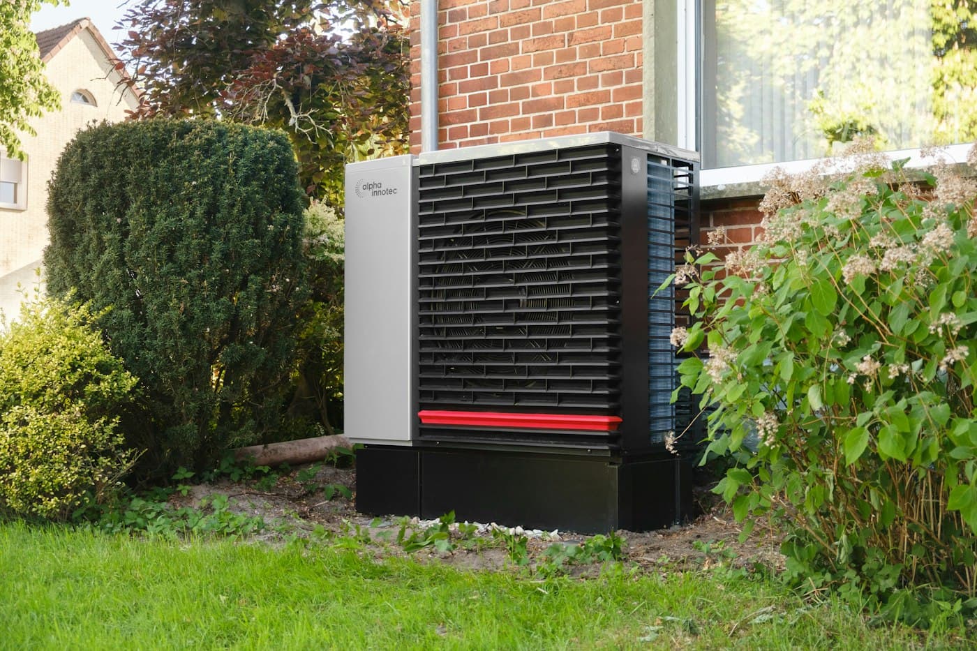 An air source heat pump beside a brick house