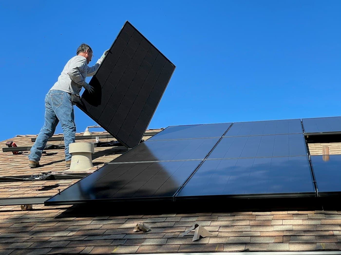 An installer fitting a solar panel on a roof